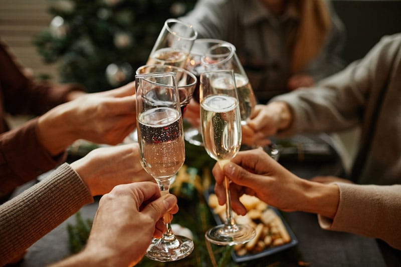 Handen met glazen champagne die samen proosten