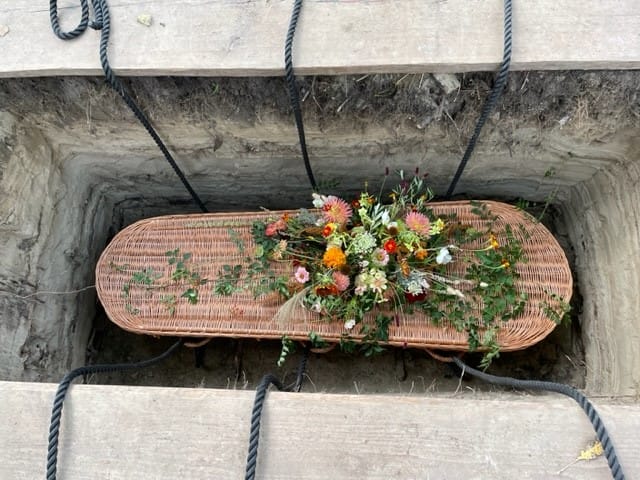 wilgenmand met bloemen in graf